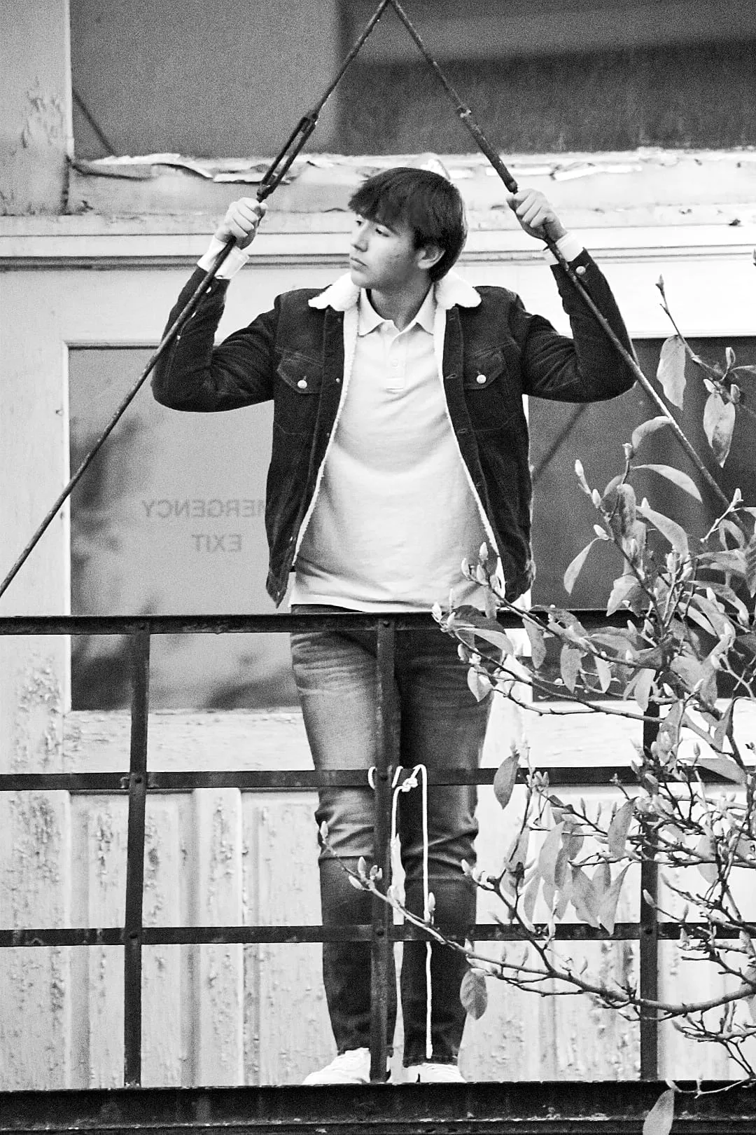 Black and white artistic portrait of young man on fire escape