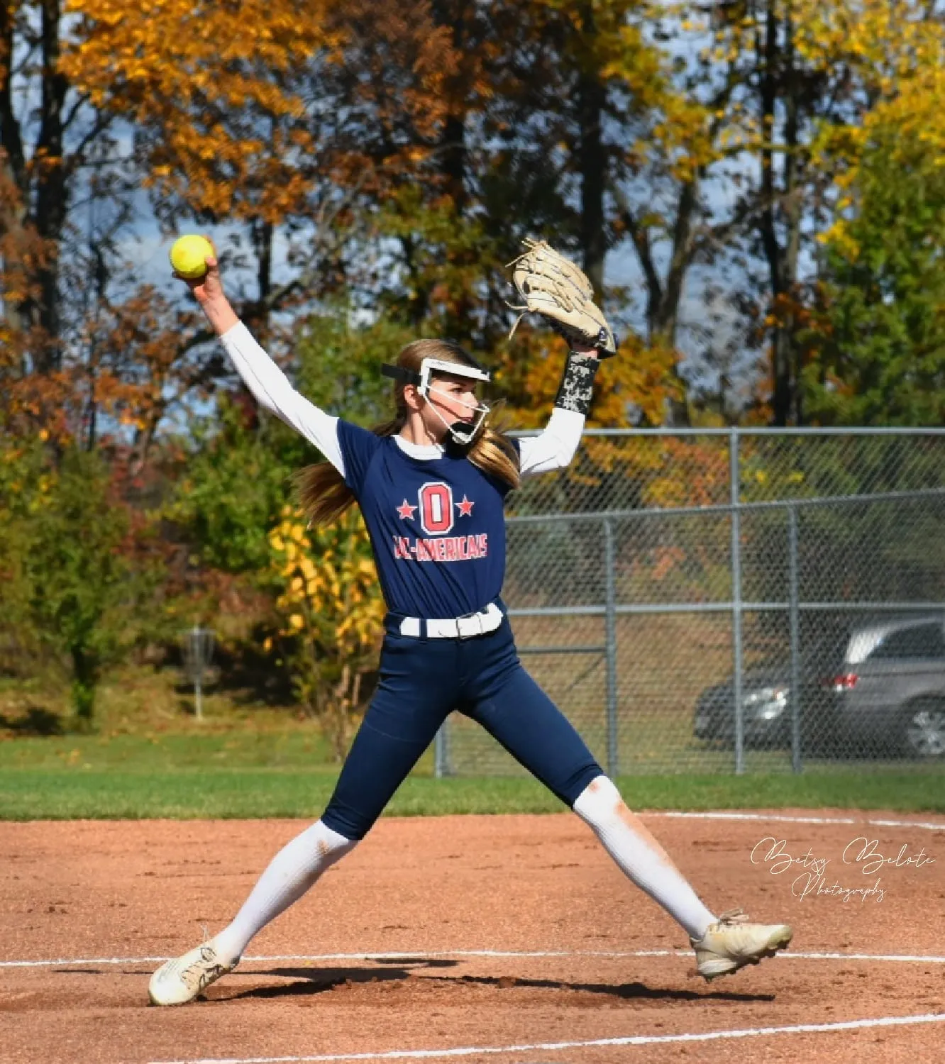 Female softball pitcher during windmill pitch on mound